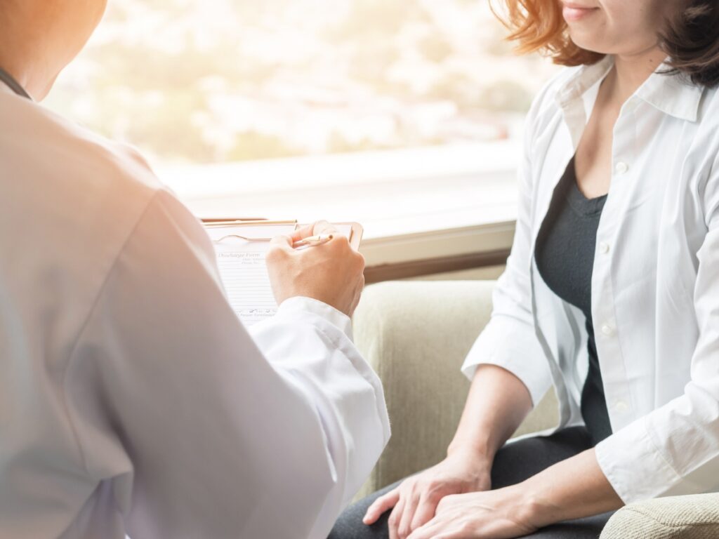 Doctor consulting with a patient about post-operative care and guidelines after breast augmentation surgery to ensure proper healing and recovery.