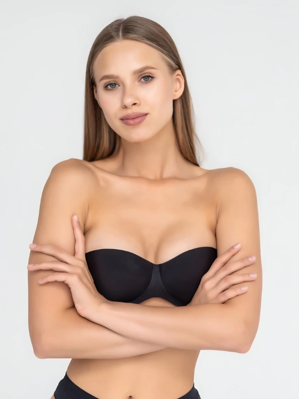 Woman with natural-looking breast augmentation, arms crossed, demonstrating post-surgery appearance.